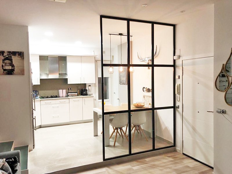 Separador de perfilería metálica lacada en negro y vidrio.