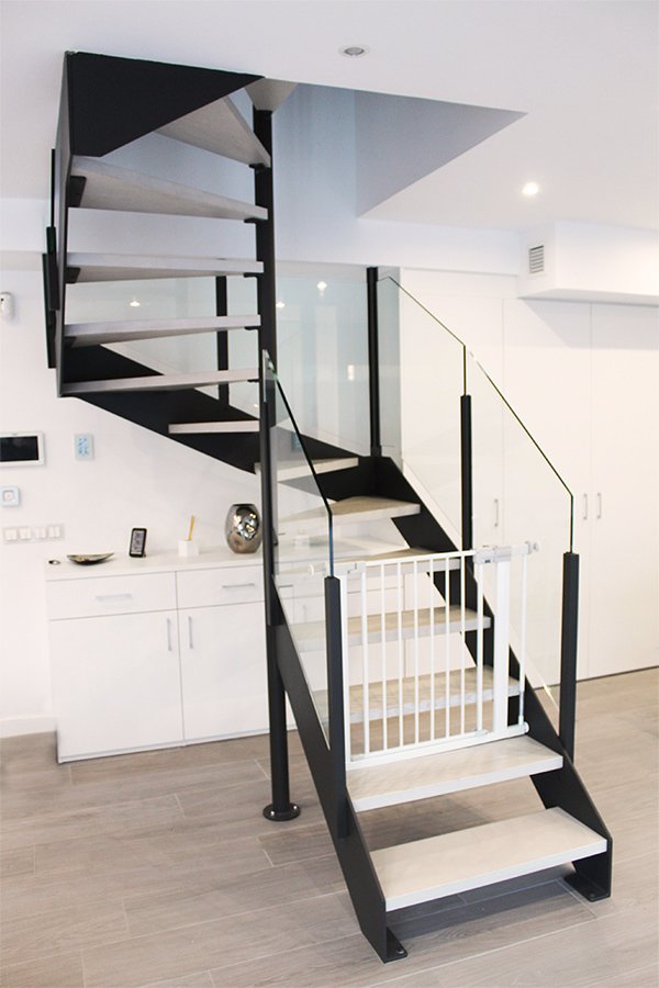 Escalera modelo “Miramón”: con zancas laterales y barandilla de vidrio.