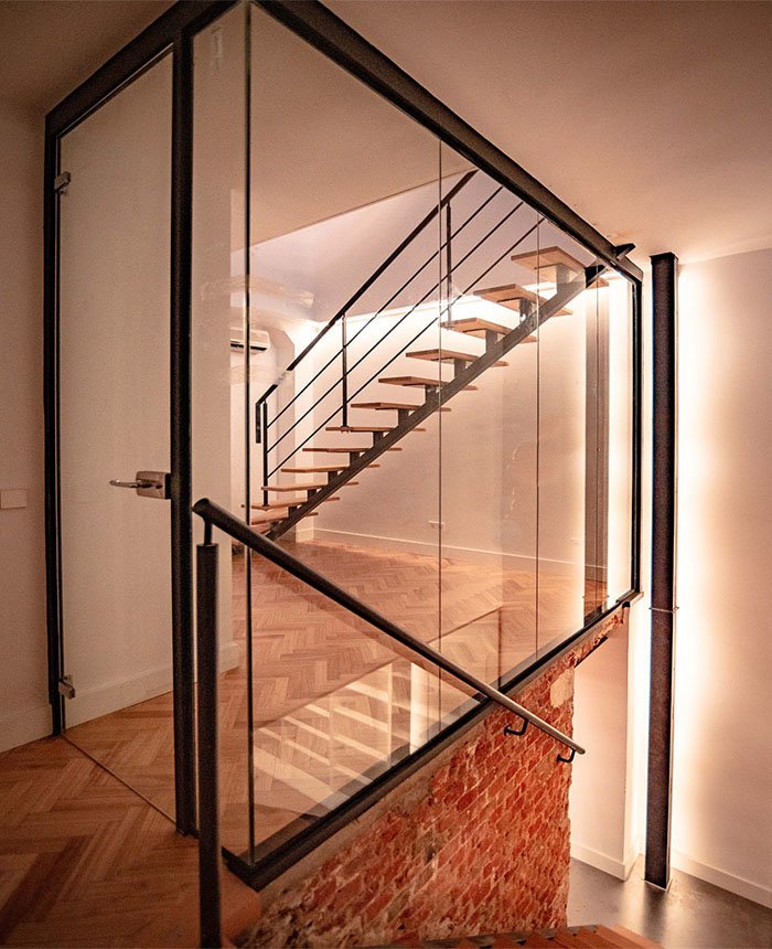 Escalera modelo “Madrid”: zanca central de acero lacada en negro con barandillas a juego.