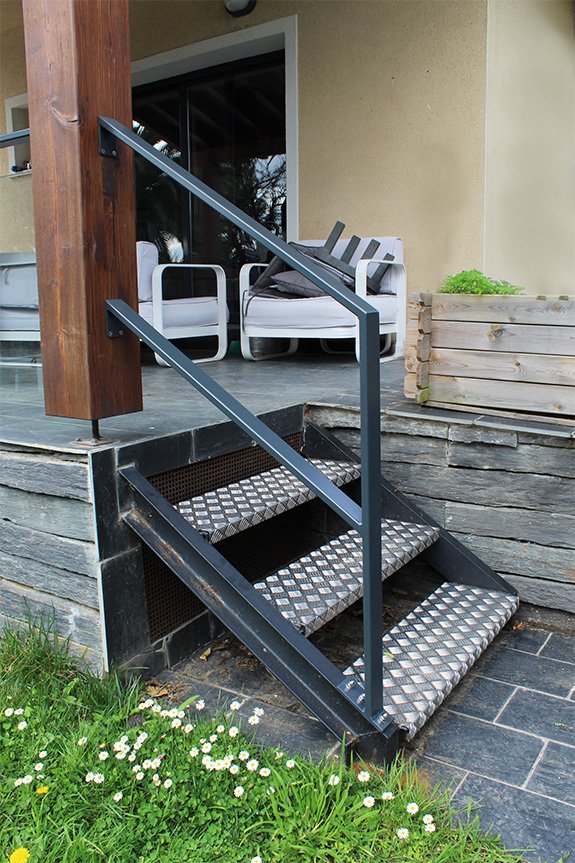 Barandilla de vidrio y escalera metálica para vivienda con jardín en San Sebastián.