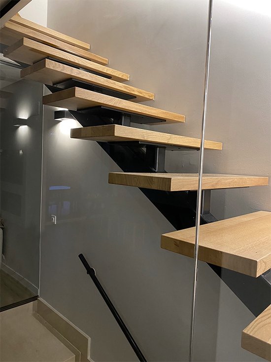 Escalera modelo “Gasteiz”: con zanca central curvada y lacada en negro.