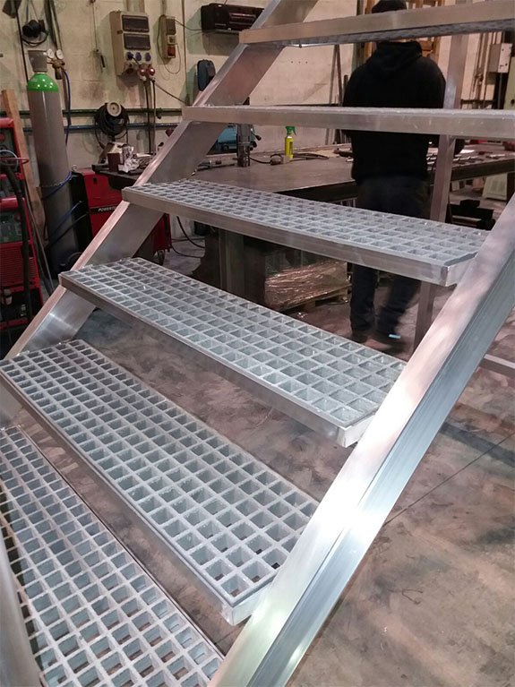 Escalera móvil de aluminio soldado con peldaños en PRFV.