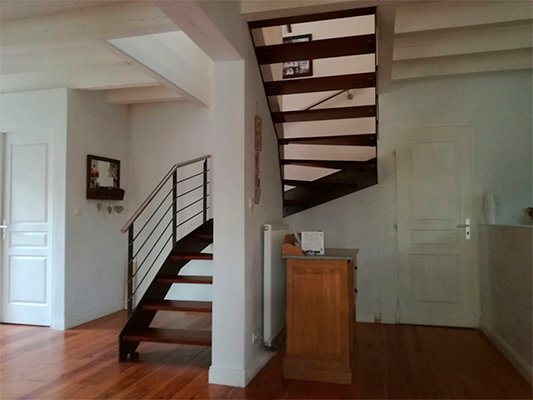 Escalera modelo «Bayona»: acabado de forja con peldaños de madera tipo merbau.