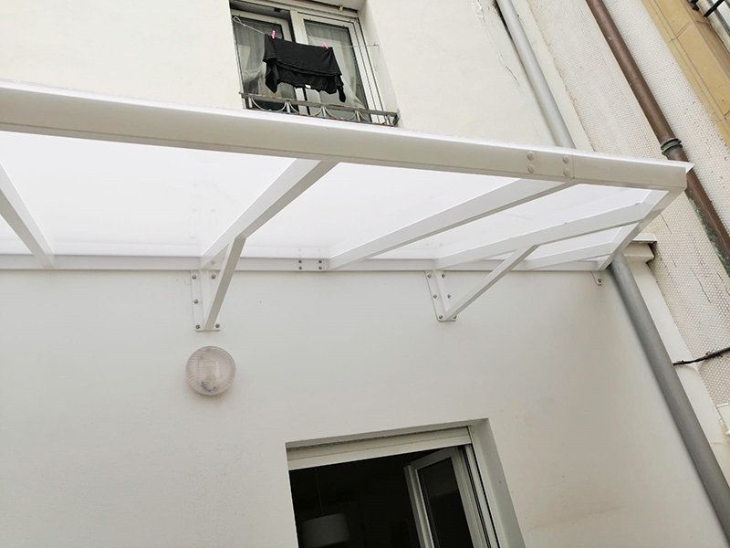 Marquesina lacada en blanco y con policarbonato compacto.