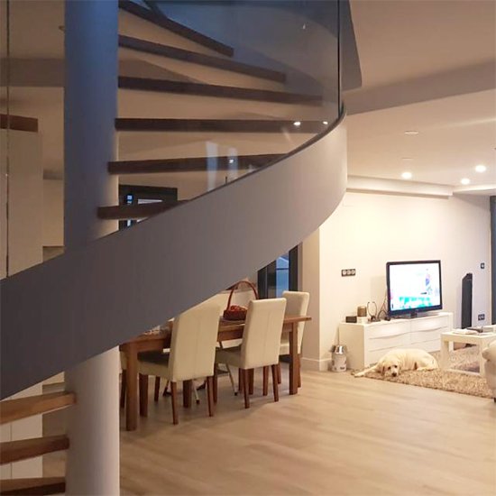 Escalera modelo “Bizkaia”: helicoidal con barandilla de vidrio curvado.