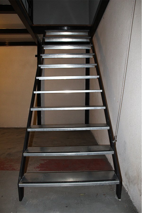 Instalación de escalera para entreplanta con sistema de elevación mediante cabestrante.