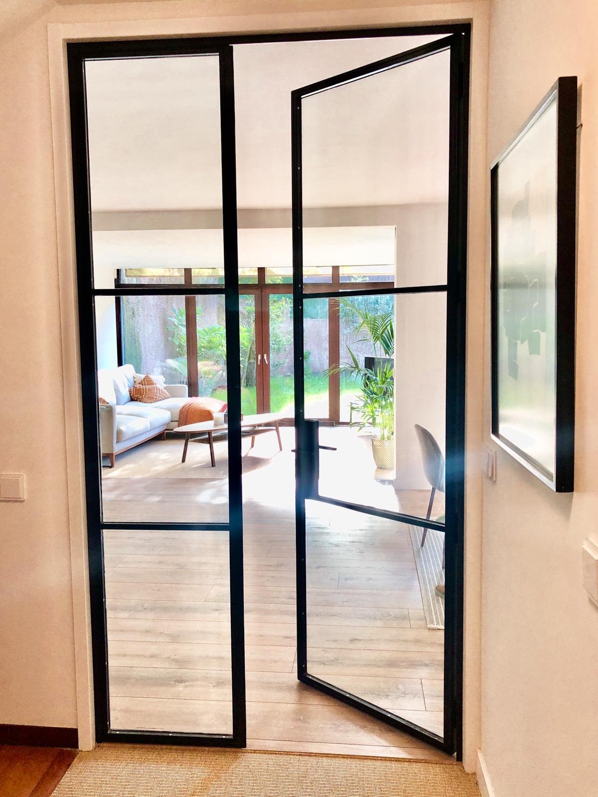 Puerta metalica de dos hojas en acero y vidrio para paso de luz