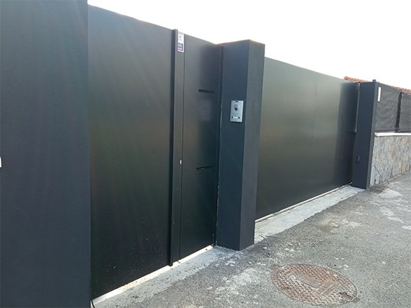 Puerta corredera motorizada de acceso a vehículos y otra peatonal en San Sebastián-Donostia.