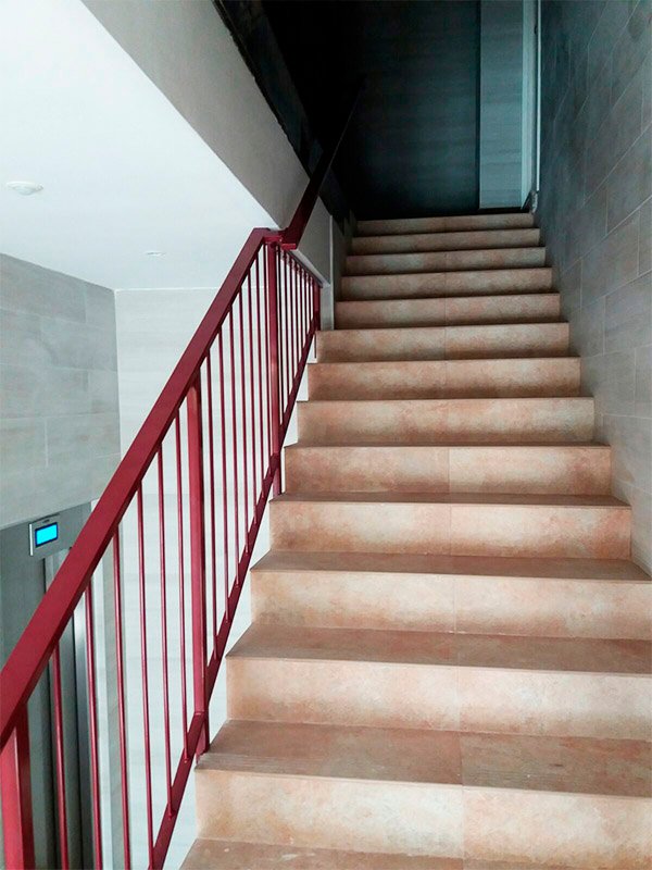 Barandilla de acero lacada en rojo para interior de portal.